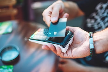 Card machine, being tapped by a debit/ credit card. 